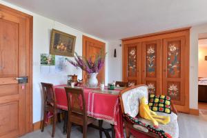 a dining room with a red table and chairs at Les Hirondelles in Orbey