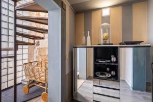 a kitchen with a glass cabinet and a staircase at Maison Boutique At Viviana in San Pietro in Lama