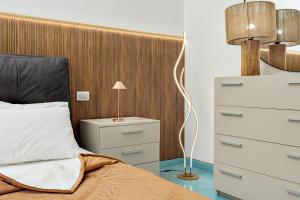 a bedroom with a bed with a wooden headboard at Colombo Apartment - by And Service in Golfo Aranci