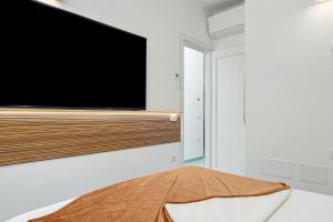 a bedroom with a flat screen tv on a wall at Colombo Apartment - by And Service in Golfo Aranci