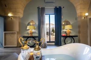 a bath tub in a room with a window at Maison Boutique At Viviana in San Pietro in Lama +21 photos