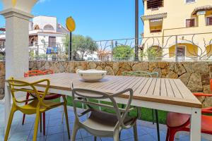 a wooden table and chairs on a patio at Colombo Apartment - by And Service in Golfo Aranci