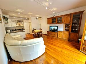a living room with a white couch and a kitchen at Barsotti House - Lucca in Lucca +27 photos