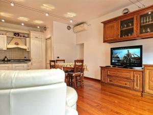 a living room with a television and a table with chairs at Barsotti House - Lucca in Lucca