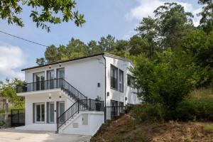 a white house with stairs on a hill at Aptos Ría San Cosme Aurora in Bendimón