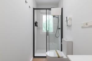 a bathroom with a shower with a toilet and a sink at Aptos Ría San Cosme Aurora in Bendimón