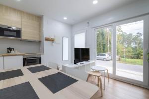 a kitchen and living room with a table and a dining room at Aptos Ría San Cosme Aurora in Bendimón
