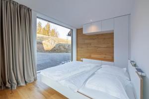 a bedroom with a bed and a large window at Lippenhof - Unter der Linde in Unterkirnach
