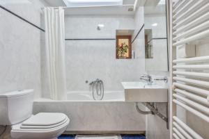 a white bathroom with a toilet and a sink at Palailimnos in Palaiólimnos +24 photos