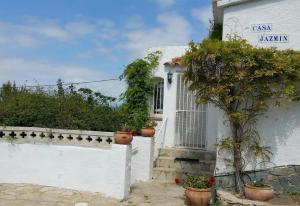 a white house with potted plants on the side of it at Casa Jazmin in Roses