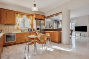 a kitchen with wooden cabinets and a table and chairs at Palailimnos in Palaiólimnos