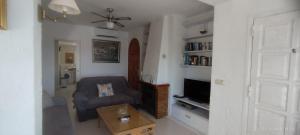 a living room with a couch and a tv at Casa Jazmin in Roses