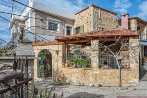 a stone house with a gate and a building at Palailimnos in Palaiólimnos
