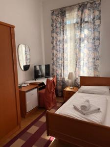 a bedroom with a bed and a desk with a computer at Hotel Stadtpark in Vienna