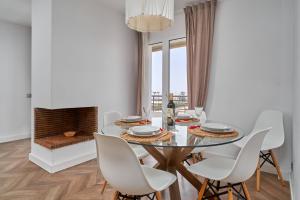 a dining room with a glass table and white chairs at La Mejor in Torrox