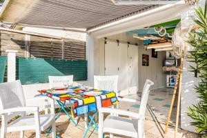 a patio with a table and white chairs at Maison vacances La Terrière in La Tranche-sur-Mer