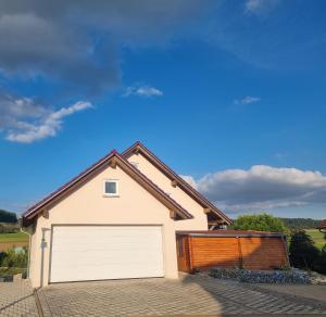 a detached house with a white garage at Ferienwohnung Biosphärenblick in Münsingen