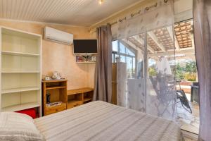 a bedroom with a bed and a sliding glass door at Chez Gaston - Chambre in Saint-Drézéry