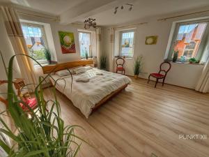 a bedroom with a bed and two chairs and windows at Wohnung 8 in Burghaslach +35 photos
