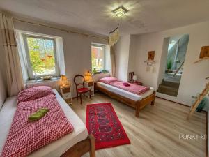 a bedroom with two beds and a red rug at Wohnung 8 in Burghaslach