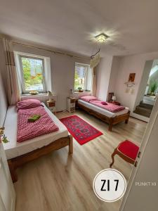a bedroom with two beds and a red rug at Wohnung 8 in Burghaslach