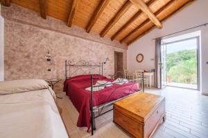 a bedroom with a bed and a wooden table at Antico Casale Gioiosa Marea in Gioiosa Marea +38 photos