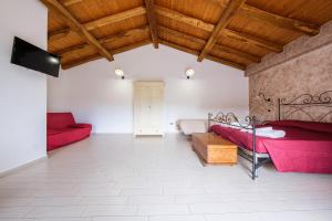 a bedroom with red beds and a wooden ceiling at Antico Casale Gioiosa Marea in Gioiosa Marea