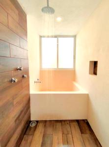 a bath tub in a bathroom with a window at Casa Colibri Central Villa with Private Pool and Tub Merida in Mérida +11 photos