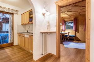 a kitchen and dining room with a table and chairs at Cesa Valeria App Sonia in Ortisei +18 photos