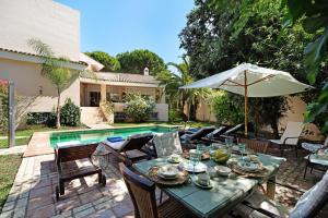 a patio with a table and chairs and an umbrella at Olmo tree in Vista Hermosa