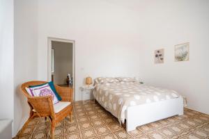a bedroom with a bed and a chair at Maison Valentina in Monopoli
