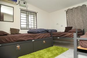 two beds in a room with a mirror and green rug at Connect Backpackers Hostel in Chennai