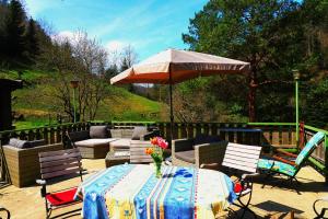 a patio with a table with an umbrella and chairs at Ferienwohnung Teich 11, 126qm in Gütenbach