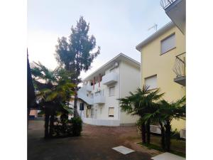 a white building with trees in front of it at Residenza Stella Y in Bibione