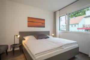 a bedroom with a large bed with a window at Ferienwohnung Montfort in Langenargen