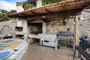 an outdoor kitchen with a grill and an oven at Il Nido in Pompeiana