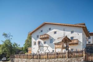 a white building with a wooden fence in front of it at Hatzeshof Heustadel in Laion