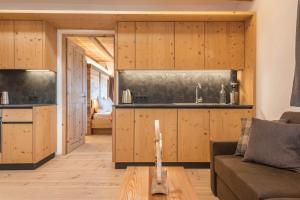 a kitchen and living room with wooden cabinets at Hatzeshof Heustadel in Laion