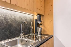 a kitchen sink with a soap dispenser on a counter at Hatzeshof Heustadel in Laion +24 photos