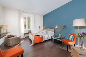 ローマにあるCorso Vittorio 308の青い壁のベッドルーム1室、ベッド1台、ソファが備わります。