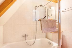 a bathroom with a shower and a bath tub at Charmantes Ferienhaus mit Garten in Siegsdorf +22 photos