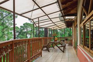 a wooden balcony with a table and benches on it at Cabañas Monte Escondido in Mazamitla