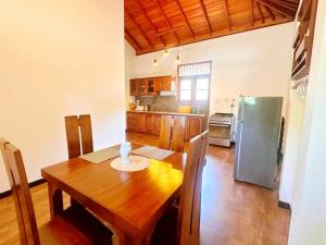 a kitchen with a wooden table and a refrigerator at Anu villa Bentota in Bentota