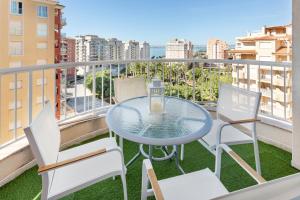 a glass table and chairs on a balcony with a view at Mistral Apartment La Manga in San Javier