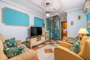 a living room with two chairs and a flat screen tv at Casa Carmen in Almuñécar