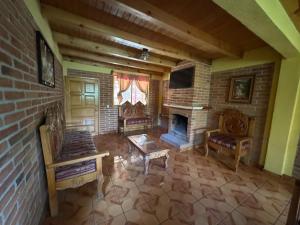 a living room with two chairs and a fireplace at Cabañas Monte Escondido in Mazamitla +23 photos