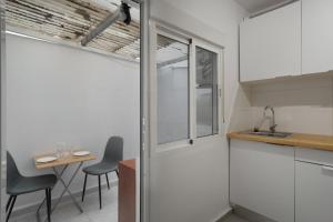 a kitchen with a table and chairs and a window at Loft Guanapay 2 in Los Cristianos +14 photos