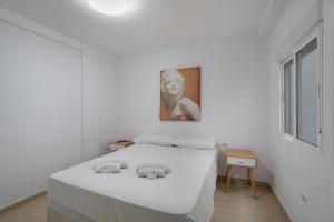 a white bedroom with a bed with two elephants on it at Loft Guanapay 2 in Los Cristianos