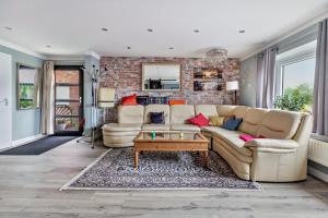 a living room with a couch and a brick wall at Bungalow vor Sylt in Klanxbüll
