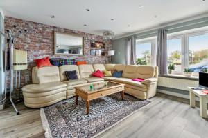 a living room with a couch and a brick wall at Bungalow vor Sylt in Klanxbüll